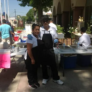 a man and a woman standing in front of a table