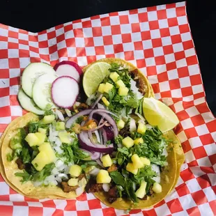 two tacos on a red and white checkered paper