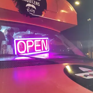 a neon sign on the hood of a car