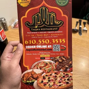 a hand holding a menu for a restaurant