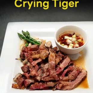 a plate of meat with a bowl of dipping sauce