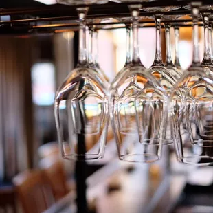 wine glasses hanging from a bar