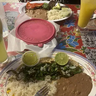 Plate in view is cactus tacos, further away is the carne asada plate. The carne asada plate came with warm tortillas.