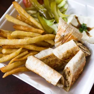 Syrian Arabic shawarma in hand made saj bread with garlic sauce and fries.