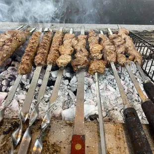 a variety of meats cooking on a grill