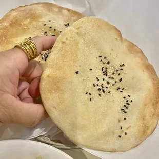 two flat breads with sesame seeds on them