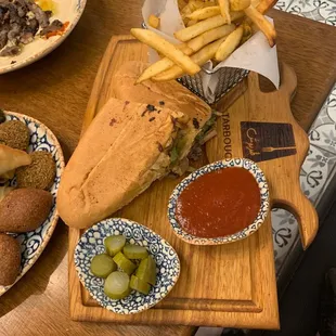 a sandwich and fries on a cutting board