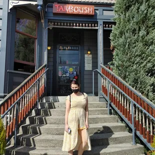 a woman standing in front of a restaurant