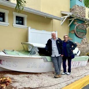 two people standing next to a boat