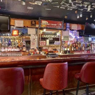 a bar with red chairs