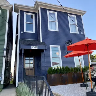 the front of the house with a red umbrella