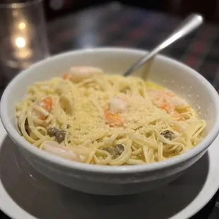 a bowl of pasta with shrimp and vegetables
