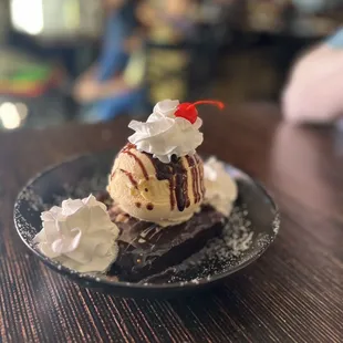 a chocolate sundae with whipped cream and a cherry on top