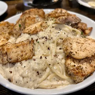 a plate of pasta with chicken and parmesan cheese