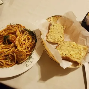 Spaghetti with meatballs, with meat sauce and garlic bread.