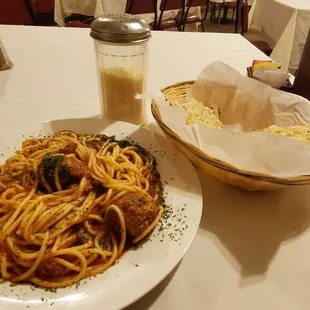 Spaghetti and meatballs, garlic bread, iced tea, parmesan cheese and Nuvole Bianche playing.