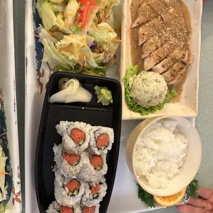 Dinner combo- sesame chicken and sushi, includes rice and salad.