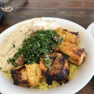 Build Your Own Bowl with chicken kebab, yellow rice, tabouli, hummus, and cabbage slaw.