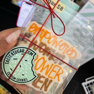 a hand holding a box of cookies