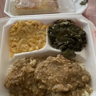 Smothered pork chops with rice and gravy , Mac and cheese, collards, cornbread