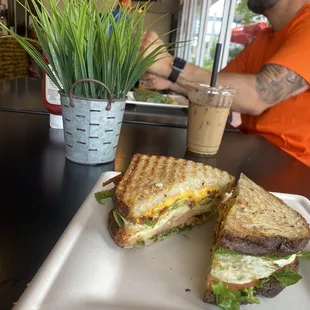 a man sitting at a table with a sandwich