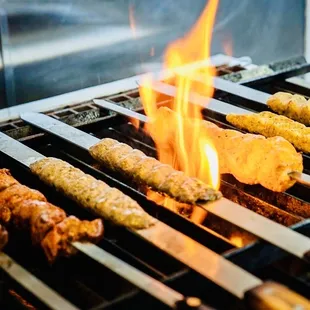 skewers on a grill with flames