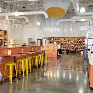 the inside of a store with tables and stools