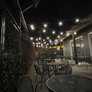 tables and chairs outside a restaurant at night