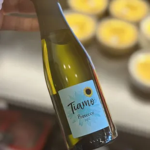 a hand holding a bottle of wine