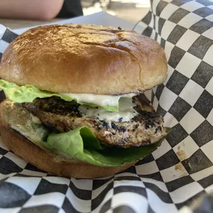 a chicken burger with lettuce and cheese