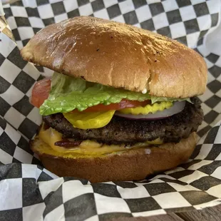a hamburger with lettuce, tomato, and cheese