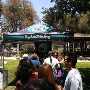 a crowd of people standing under a tent