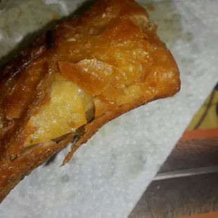 a piece of pizza on a piece of wax paper