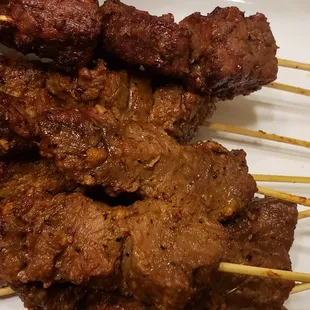 meat skewers on a white plate