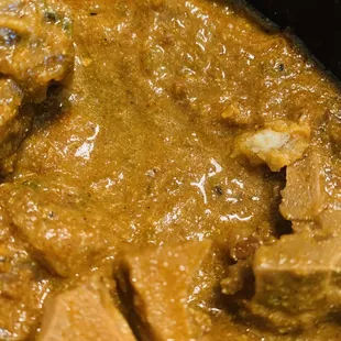 Goat curry, with loads of bones and hair in top right corner.