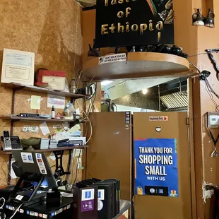 a small store with a sign above the counter