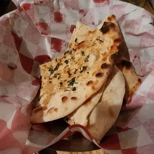 The tasteless garlic Naan that looks good tastes bland .
