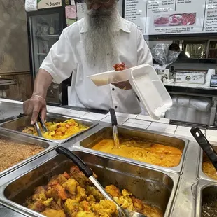 a man serving food at a buffet