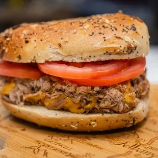 a beef sandwich on a wooden cutting board