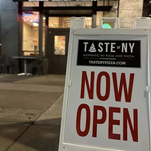 a now open sign in front of a restaurant