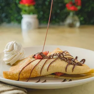 a crepe with whipped cream and chocolate