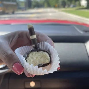 a hand holding a piece of cake