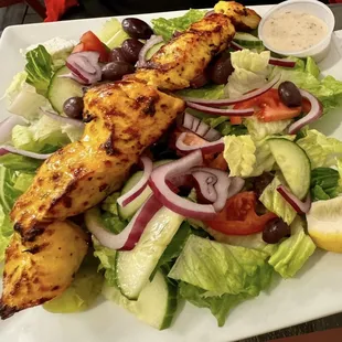 Over salad. 
Choice of meats: Khoobideh skewers,Joojeh Kabobs,Kofta, veggie Kofta,