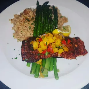 Blackened salmon filet topped with mango salsa, rice pilaf roasted asparagus.