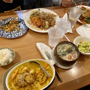 In order from bottom left to right. Yellow curry, small bowl of tum kha, drunken noodles, basil fried rice.