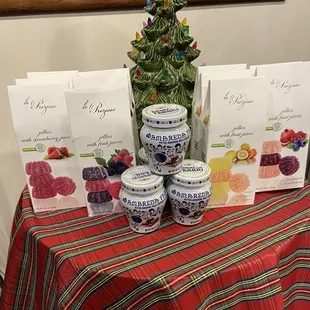 a table with a christmas tree, jars of candies, and cards