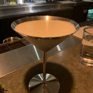 a martini in a martini glass on a counter