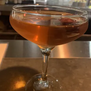 a cocktail in a coupe glass on a bar