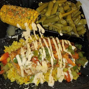 Salmon over yellow rice with green beans and corn.