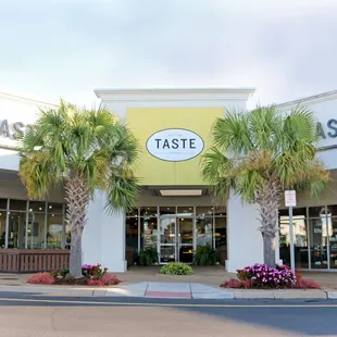a storefront with palm trees in front of it